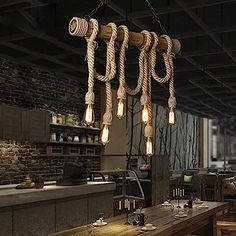 a wooden table topped with lots of light bulbs hanging from it's ceiling beams