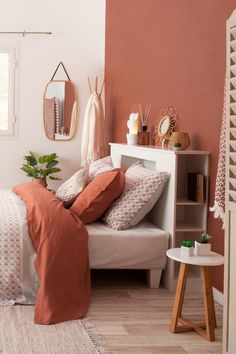 a bedroom with pink walls and white bedding, pillows and blankets on the bedspread