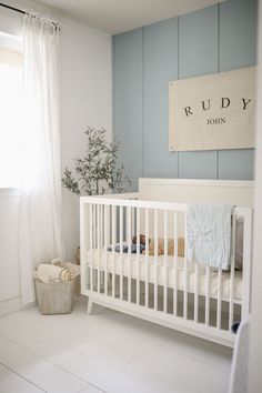 a baby's room with a white crib and blue walls