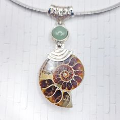 Center Stone: Ammonite Fossil Center Stone Cut: Freeform, Surface Polished Dimensions: 1.5"x1.1" -  Side Stone: Aventurine Side Stones Cut: Round Cabochon Side Stones Dimensions: 11mm - Setting: Stainless Steel, Stamped Length of Omega Necklace: 17" w/ 2" Extender Condition: Excellent, Never Worn - The omega necklace alone is worth the cost of admission Stainless steel is tarnish resistant and extremely durable. This is the EXACT necklace that you'll be receiving, so please look at the pictures closely to ensure that you'll love it! Your necklace will be carefully packaged in a jewelry box. Your item will ship from Wisconsin within 1-3 days of purchase. Spiral Natural Stones Jewelry Gift, Unique Green Spiral Jewelry, Omega Necklace, Ammonite Fossil, Stone Cuts, Green Aventurine, Necklace Set, Wisconsin, Fossil