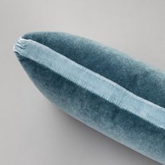 a close up of a blue pillow on a gray surface