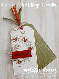 a close up of a tag on a wooden surface with text that reads stampin'up college wreaths