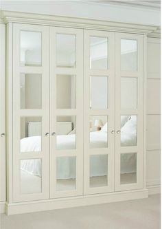 an image of a bedroom with mirrored doors on the wall and bed in the background