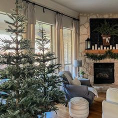 a living room filled with furniture and a christmas tree in front of a fire place