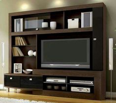 an entertainment center with a flat screen tv on it's side and shelves below