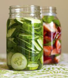 two mason jars filled with pickles and cucumbers