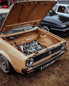 an old car with its hood open and engine in the middle of it's trunk