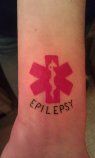 a red medical tattoo with the word college on it's wrist and an image of a woman