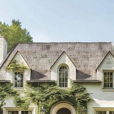 a large white house with ivy growing on it's roof and windows in the front