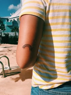 a person with a small tattoo on their arm near a swimming pool and water slide