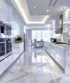 a white kitchen with marble flooring and stainless steel appliances