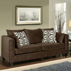 a living room scene with focus on the couch and pillows in front of the window