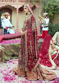 Embellished Gold Lehenga with Heavy Zardozi Worked Long Kameez in Net Chiffon is a popular deep red bridal shirt with zardozi work & intricate detailing. Paired with a rose gold tissue lehenga with heavily embellished borders to complete the look of a traditional bride. A comprehensive border dupatta is added with beautiful matching details complimenting the shirt. Shirt: Culture meets modernity. Boost your confidence and style with this red glamorous attire emphasized with the finest dense zard Embellished Anarkali Gown For Traditional Ceremonies, Georgette Lehenga For Reception, Embellished Choli For Festive Traditional Ceremonies, Bollywood Style Embellished Sets For Traditional Ceremonies, Embellished Lehenga For Traditional Ceremonies, Embellished Bollywood Sets For Traditional Ceremonies, Bollywood Style Embellished Traditional Wear For Ceremonies, Traditional Embellished Gown For Ceremonies, Festive Embellished Sets For Traditional Ceremonies