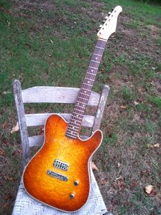 an electric guitar sitting on top of a wooden chair