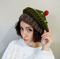 a woman wearing a knitted hat with pom poms on it's brim