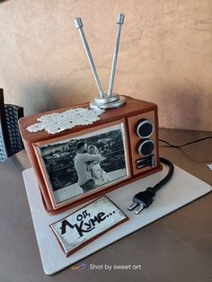 a cake made to look like an old fashioned tv set with two people on it