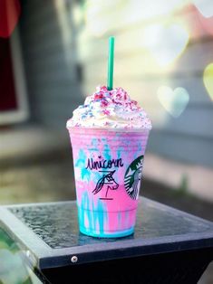 a pink and blue starbucks drink sitting on top of a table