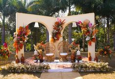 an outdoor wedding setup with wicker chairs and flowers