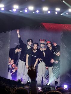 a group of young men standing on top of a stage next to each other in front of a crowd