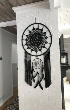 a white brick wall with a black and white dream catcher hanging from it's side