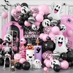 halloween decorations and balloons are displayed in front of a fireplace decorated with black, white and pink