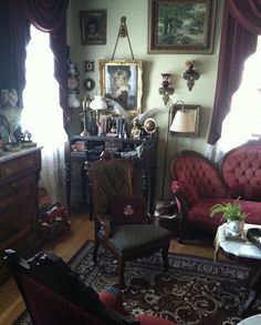 a living room filled with lots of furniture and paintings on the wall next to a window