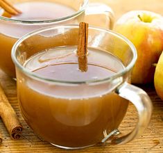 two mugs filled with cinnamon and apple cider