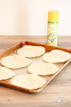 homemade tortillas on a baking sheet with a bottle of deodorant in the background