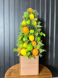 a wooden table topped with a vase filled with oranges and lemons on top of it