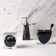 three black soap dispensers sitting next to each other on a white counter