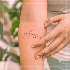 a woman's arm with the word cafna en elama tattooed on it