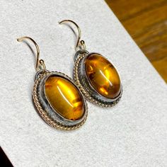 These Gorgeous Amber Earrings Are Made From Dark Antiqued Silver With Bright Gold Twisted Halos. 14k Gold Filled Ear Wires. Hallmarked .925 Sterling Silver. Genuine Baltic Amber. Matching Necklace Available. Handmade By Me And My Fellow Silversmith, Bri! Bundle And Save! Oval Ear Wire Earrings For Anniversary, Classic Yellow Oval Earrings, Classic Orange Jewelry As Gift, Classic Orange Jewelry For Gift, Classic Amber Oval Cabochon Jewelry, Oval Amber Jewelry, Orange Oval Cabochon Jewelry For Formal Occasions, Yellow Gold Oval Cabochon Earrings For Gift, Yellow Gold Oval Cabochon Earrings As Gift