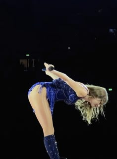 a woman is performing on stage with her leg in the air and one hand up