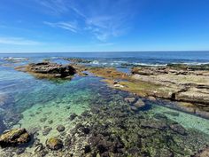 the water is crystal clear and blue with some rocks in it on the shore line