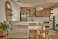 a kitchen with wooden stools next to a sink and stove top oven in it