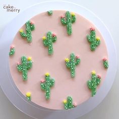 a cake decorated with green and pink frosting has cactus decorations on it's side