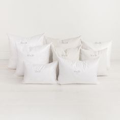 six pillows stacked on top of each other in front of a white wall and floor