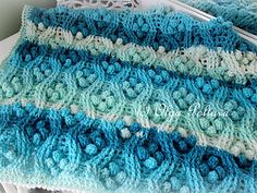 a blue and white crocheted blanket sitting on top of a table