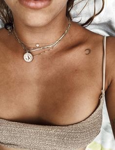 a close up of a woman wearing a bra with a necklace on her neck and chest