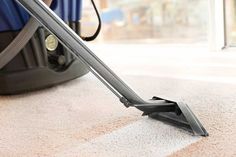 a person vacuuming the carpet with a red and white banner in front of them