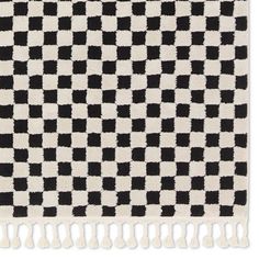 a black and white checkered rug with fringes