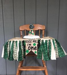 a st patrick's day table with a cake on it and a shamrock banner