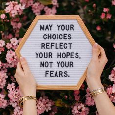 someone holding up a sign that says may your choices reflect your hopes, not your fears