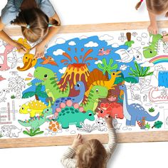 two children are playing with dinosaurs on a large floor mat, and one child is drawing