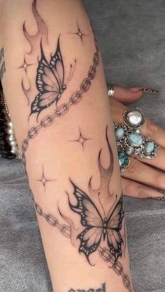 a woman's leg with a butterfly tattoo on it and chains around her ankles