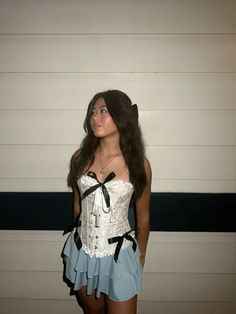 a young woman in a corset poses for the camera