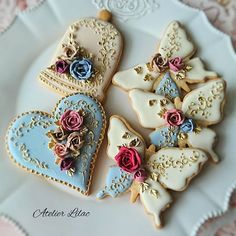 some decorated cookies are on a plate with pink and blue flowers in the middle,