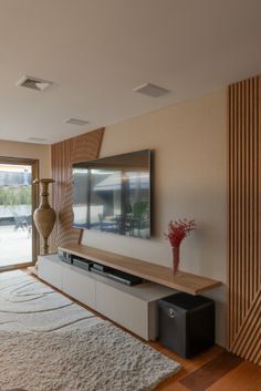 a living room filled with furniture and a flat screen tv on top of a wooden shelf