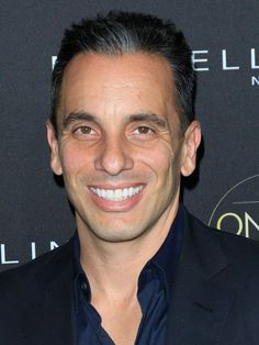 a man in a suit smiling for the camera