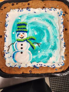 there is a frosted cookie with a snowman on it and blue icing